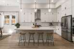 This modern kitchen boasts sleek white cabinetry and a stunning marble island, perfect for entertaining.