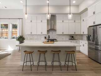 This modern kitchen boasts sleek white cabinetry and a stunning marble island, perfect for entertaining.
