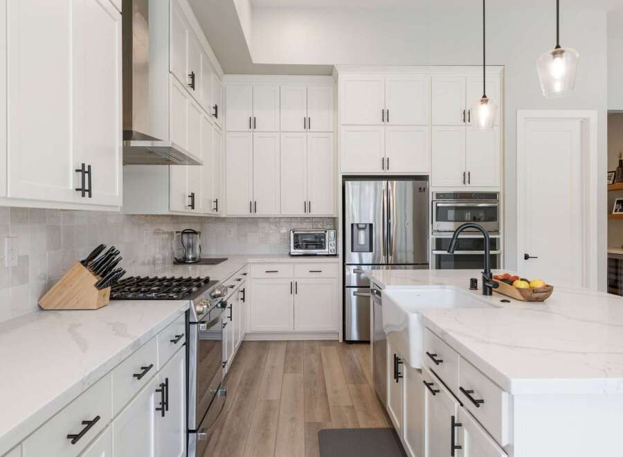Experience luxury and functionality in this stunning modern kitchen, featuring sleek white cabinetry, quartz countertops, and a professional-grade gas range.