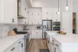 Experience luxury and functionality in this stunning modern kitchen, featuring sleek white cabinetry, quartz countertops, and a professional-grade gas range.