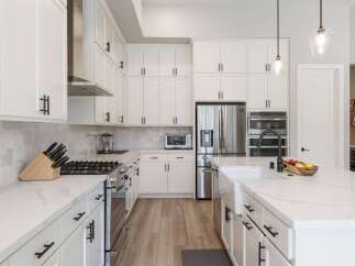 Experience luxury and functionality in this stunning modern kitchen, featuring sleek white cabinetry, quartz countertops, and a professional-grade gas range.