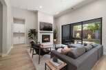 Experience modern living in this stunning living room featuring a cozy fireplace and a large sliding glass door that opens to a beautiful outdoor patio.