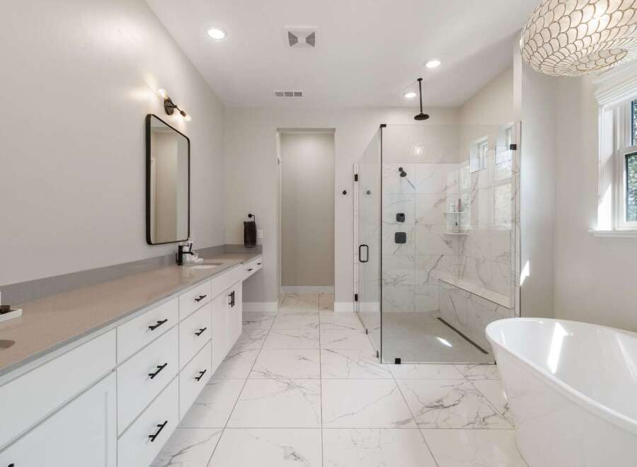 Experience luxury in this stunning master bathroom, featuring a spacious walk-in shower with marble tile and a built-in bench.