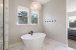 Indulge in relaxation in this luxurious bathroom, featuring a freestanding soaking tub perfect for unwinding.