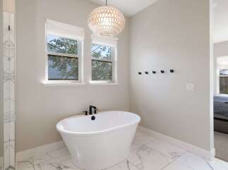 Indulge in relaxation in this luxurious bathroom, featuring a freestanding soaking tub perfect for unwinding.