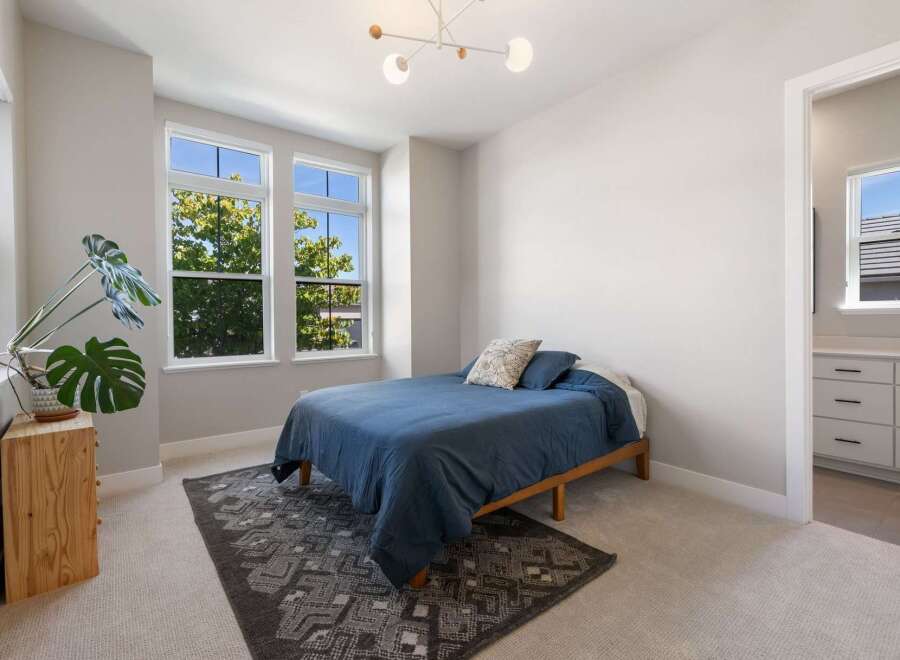 This charming bedroom features a comfortable queen-sized bed dressed in a deep blue comforter, complemented by a decorative throw pillow.
