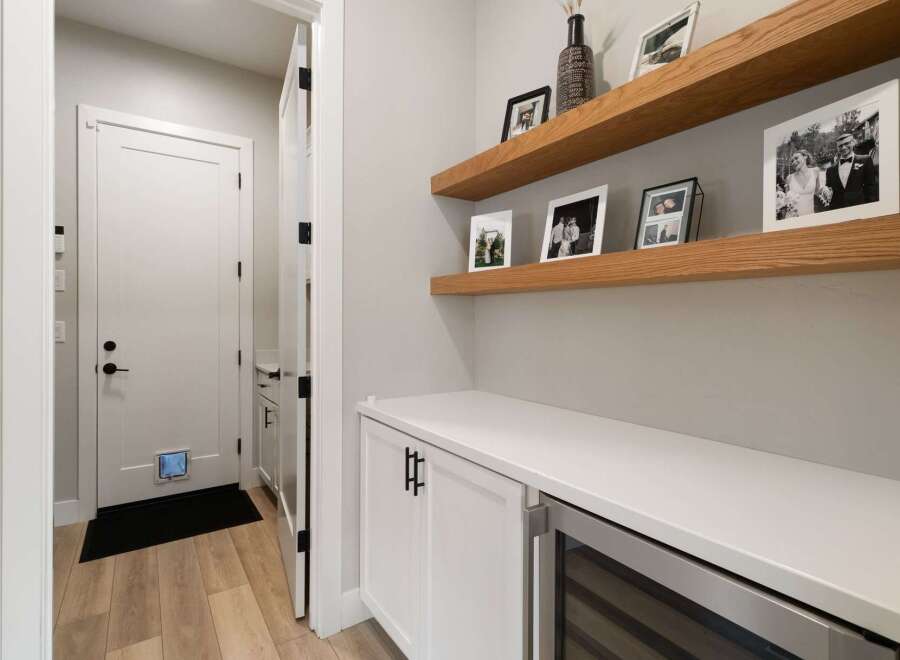 This modern entryway features a sleek white cabinet with a built-in wine fridge, perfect for entertaining.