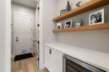 This modern entryway features a sleek white cabinet with a built-in wine fridge, perfect for entertaining.