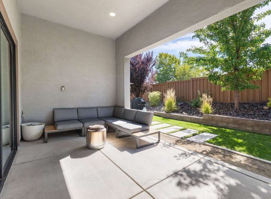 Enjoy outdoor living in this modern patio space, featuring a comfortable sectional sofa and a sleek fire pit.