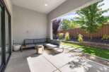 Enjoy outdoor living in this modern patio space, featuring a comfortable sectional sofa and a sleek fire pit.