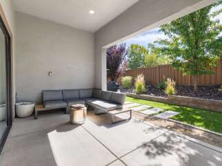 Enjoy outdoor living in this modern patio space, featuring a comfortable sectional sofa and a sleek fire pit.