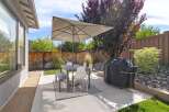 Enjoy outdoor living in this charming backyard featuring a spacious patio perfect for al fresco dining.