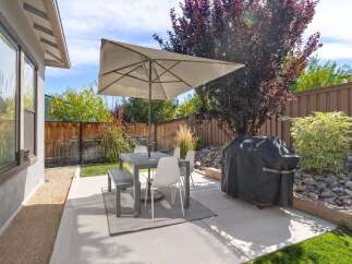Enjoy outdoor living in this charming backyard featuring a spacious patio perfect for al fresco dining.