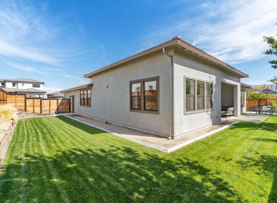 Experience modern living in this stunning home featuring a spacious, manicured lawn perfect for outdoor activities and relaxation.