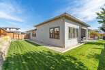 Experience modern living in this stunning home featuring a spacious, manicured lawn perfect for outdoor activities and relaxation.