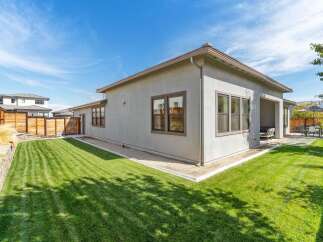 Experience modern living in this stunning home featuring a spacious, manicured lawn perfect for outdoor activities and relaxation.