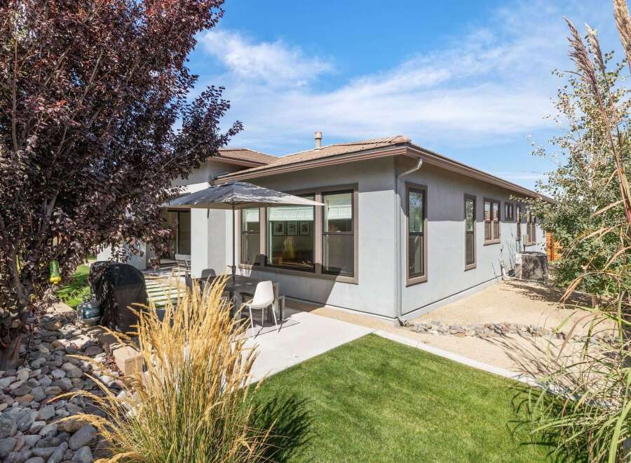 Enjoy outdoor living with this charming backyard featuring a covered patio, perfect for al fresco dining.