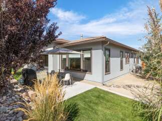 Enjoy outdoor living with this charming backyard featuring a covered patio, perfect for al fresco dining.