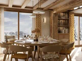 Experience luxurious mountain living in this stunning dining room, featuring a grand round table set for an intimate dinner.
