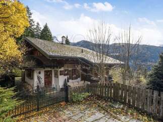 Nestled amidst the vibrant autumn foliage, this charming chalet offers a serene mountain retreat.