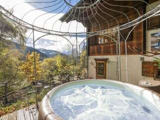 Experience ultimate relaxation in this stunning outdoor hot tub, offering breathtaking mountain views and a serene natural setting.