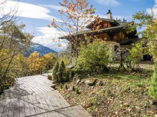 Experience the charm of this alpine home nestled amidst vibrant autumn foliage and majestic mountain views.