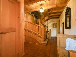 Step into a charming entryway featuring a beautiful wooden staircase and a rustic wooden door.
