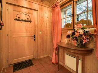 Step into a charming entryway featuring warm wooden paneling and a classic wooden door.