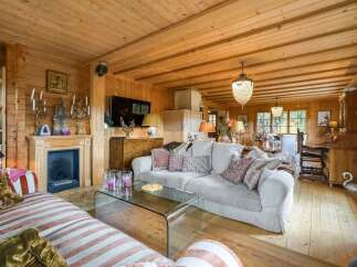Experience rustic charm in this beautifully appointed log cabin living room, featuring a cozy fireplace and abundant natural wood finishes throughout.
