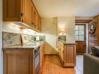 This charming kitchen features warm, natural wood cabinetry and granite countertops, offering a cozy and functional space.
