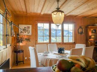 Experience rustic charm in this dining room, featuring warm wood paneling and a stunning chandelier.