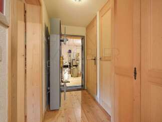 Step into this charming hallway featuring warm wooden floors and light-colored doors, creating a bright and inviting atmosphere.