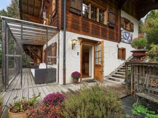 Experience the charm of this alpine retreat, featuring a covered outdoor living space with comfortable seating, perfect for enjoying the crisp mountain air.