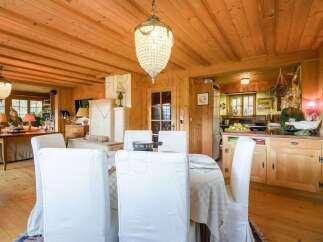 Experience rustic charm in this beautifully appointed dining room and kitchen area, featuring warm wooden paneling throughout.