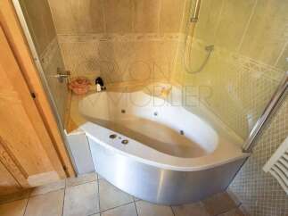 Indulge in relaxation with this luxurious corner jacuzzi bathtub, perfect for unwinding after a long day.