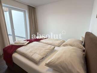 Experience comfort and style in this beautifully appointed bedroom, featuring a plush bed with crisp white linens and accent pillows.