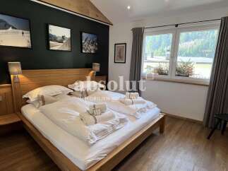 Experience cozy mountain living in this charming bedroom, featuring a comfortable wooden bed adorned with crisp white linens and plush towels.