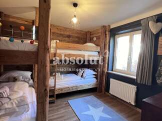 This charming bedroom features a rustic wooden bunk bed setup, perfect for families or groups.