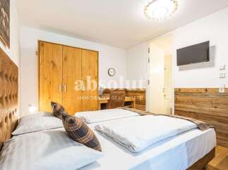 Experience comfort and style in this beautifully appointed bedroom, featuring a plush tufted headboard and crisp, white linens on a spacious bed.