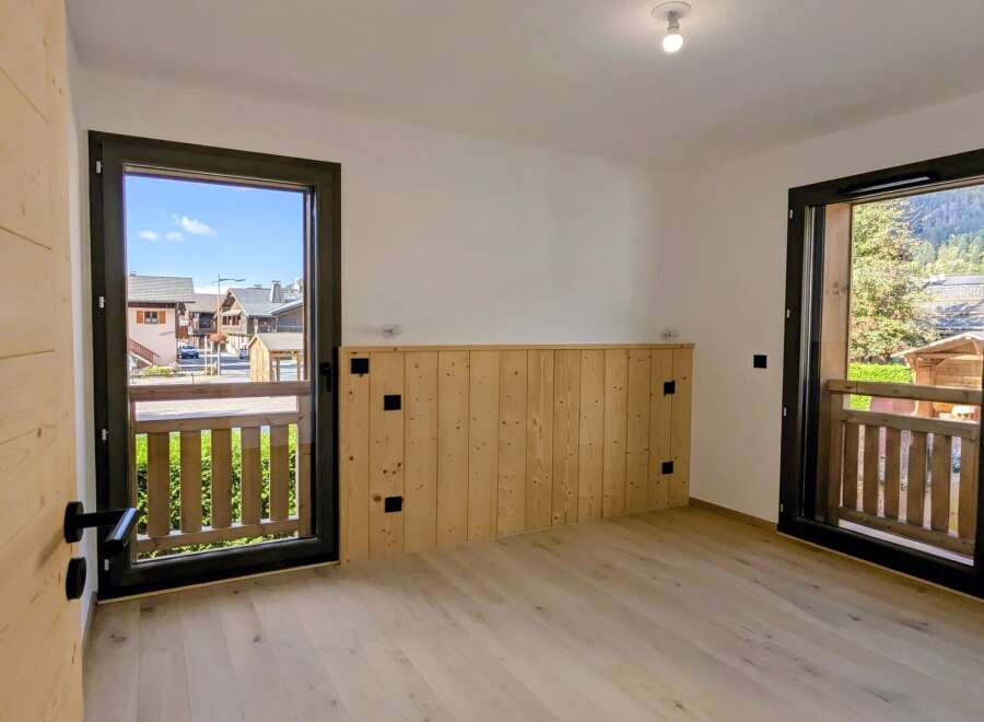 Experience the charm of mountain living in this beautifully appointed room, featuring natural wood paneling and a light wood floor.