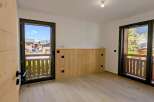 Experience the charm of mountain living in this beautifully appointed room, featuring natural wood paneling and a light wood floor.