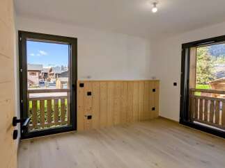 Experience the charm of mountain living in this beautifully appointed room, featuring natural wood paneling and a light wood floor.