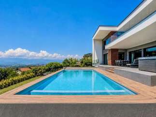 Experience luxury living in this stunning modern villa, featuring a pristine infinity pool and a relaxing hot tub.