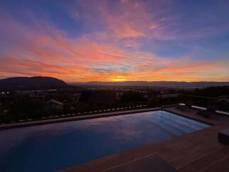 Experience breathtaking sunsets from your private infinity pool, overlooking a serene landscape.