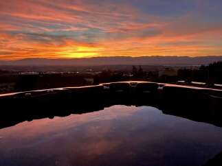 Experience breathtaking sunsets from your private hot tub, offering panoramic views of the valley and distant mountains.