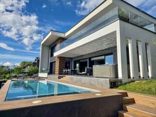 Experience luxury living in this modern architectural masterpiece featuring a stunning infinity pool and an integrated hot tub, perfect for relaxation and entertainment.