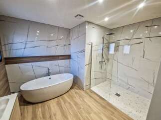 Experience modern luxury in this stunning bathroom featuring a freestanding soaking tub and a spacious walk-in shower.