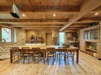 Experience rustic charm in this beautifully appointed dining room, featuring a large wooden table surrounded by classic chairs, perfect for gathering with loved ones.