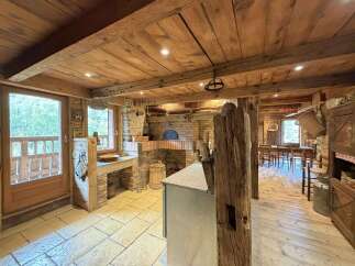 Experience rustic charm in this unique kitchen featuring a traditional brick pizza oven and a stone countertop.
