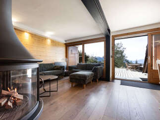 Experience cozy living in this mountain retreat, featuring a modern fireplace and plush seating.